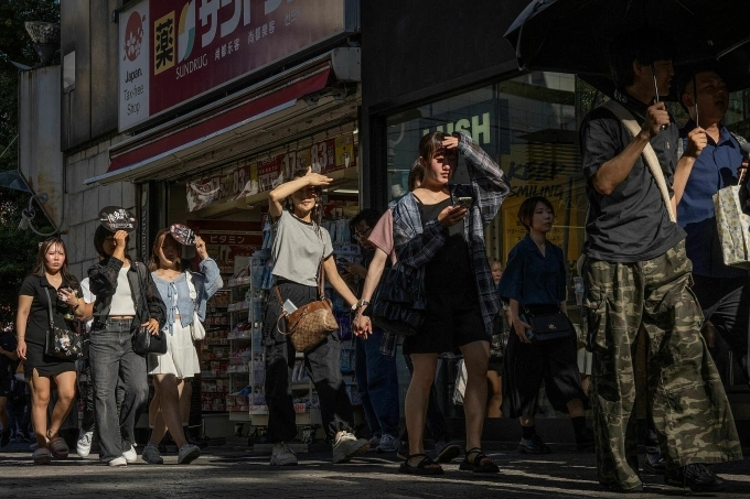 Người dân đi bộ giữa nắng nóng ở Tokyo, Nhật Bản, ngày 26/7. Ảnh: AFP
