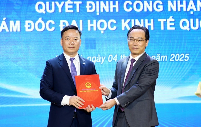 Thứ trưởng Hoàng Minh Sơn (phải) trao quyết định cho tân giám đốc Đại học Kinh tế Quốc dân. Ảnh: NEU