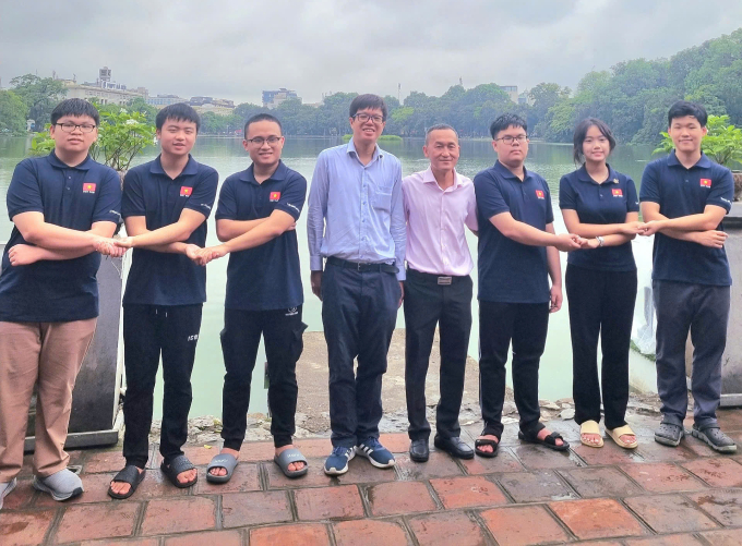 Thầy Hùng (đeo kính) cùng TS Nguyễn Chu Gia Vượng, trưởng đoàn Việt Nam dự IMO 2025, và 6 thí sinh. Ảnh: Nhân vật cung cấp