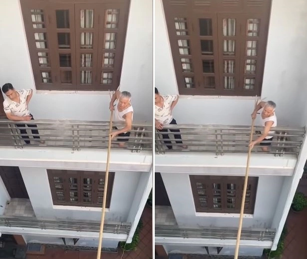 Người đàn ông dùng gậy ngăn hàng xóm mở cửa sổ hướng sang nhà mình. Ảnh: cắt từ clip