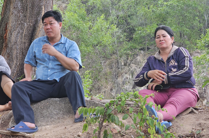 Bố mẹ của nam thanh niên ngồi dưới chân núi chờ thông tin tìm kiếm, chiều 6/8. Ảnh: Bùi Toàn
