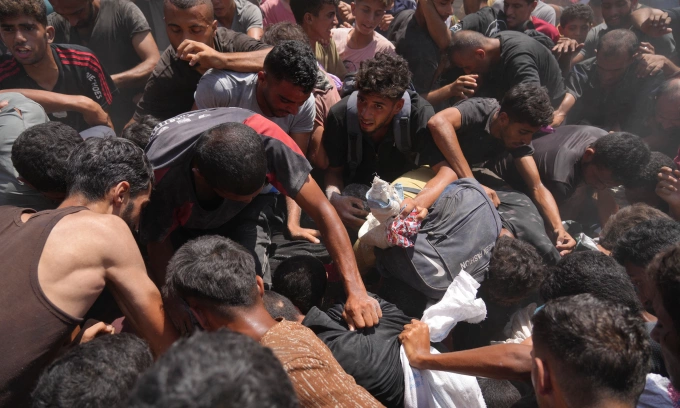 Người dân tranh nhau lấy hàng viện trợ thả xuống bằng dù tại miền bắc Gaza hôm 7/8. Ảnh: AP