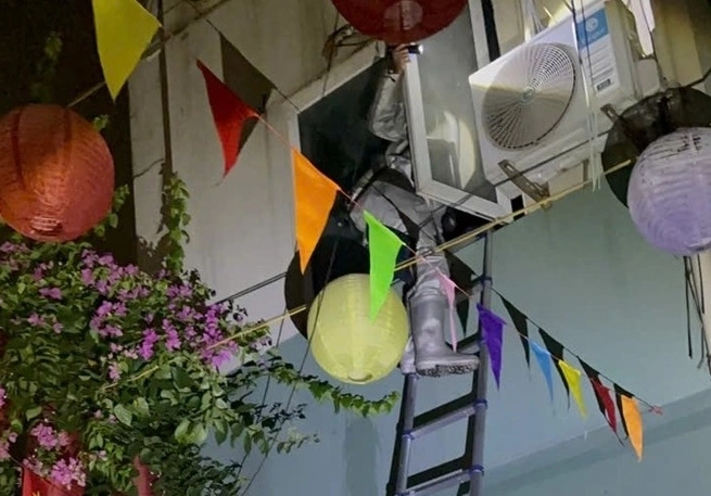 Cảnh sát phòng cháy tiếp cận cửa sổ tầng 2 để đưa người bị kẹt ra ngoài. Ảnh: Hương Chu
