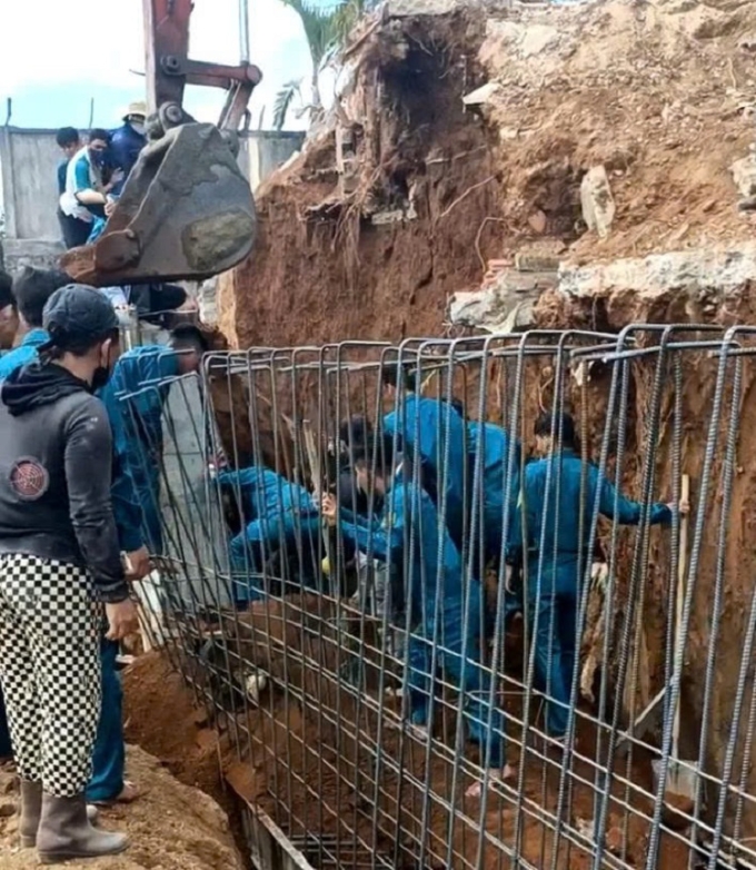Lực lượng chức năng tìm cách cứu nạn nhân bị đất vùi lấp. Ảnh cắt từ video