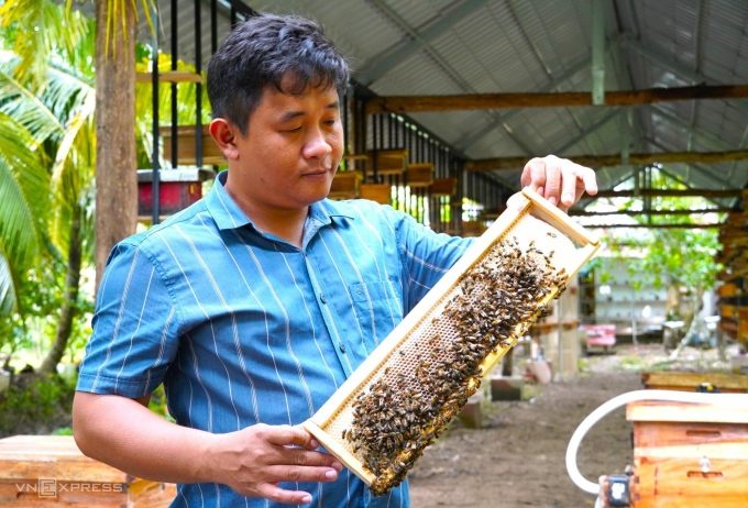 Anh Nguyễn Minh Tùng với một cầu ong chứa mật. Ảnh: An Minh