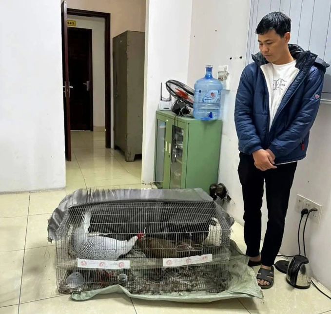 Anh Thái Khắc Thành bên chuồng sắt nhốt gà lôi trắng, thời điểm bị bắt. Ảnh: C.An