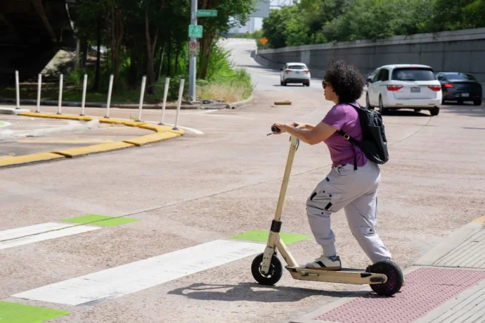 Claudia Vargas Corletto lái xe scooter điện đến chỗ làm ở Montrose, Houston. Ảnh: HC