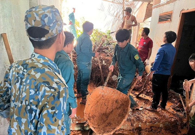Một nhà dân bị lũ gây sập tường được lực lượng dân quân giúp dọn dẹp. Ảnh: Hoài Thanh