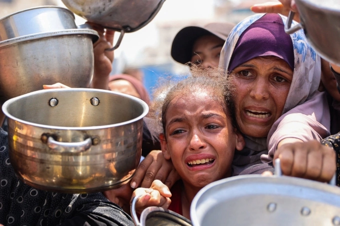 Người Palestine chờ nhận bữa ăn tại một trung tâm phân phối thực phẩm ở Gaza City ngày 13/8. Ảnh: AFP