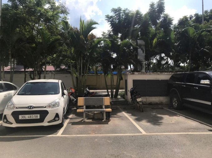 Chiếc ghế đá được khóa chặt cùng cục bê tông, chiếm trọn một vị trí đỗ xe giữa sân. Ảnh: Facebook