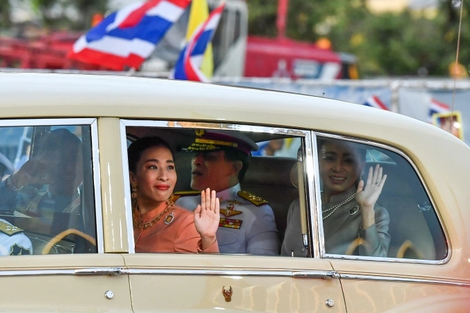 Công chúa Thái Lan Bajrakitiyabha Mahidol (áo cam) vẫy chào người dân trên đường đến Cung điện Hoàng gia ở Bangkok năm 2020, phía sau là Quốc vương Maha Vajiralongkorn và Hoàng hậu Suthida. Ảnh: AFP
