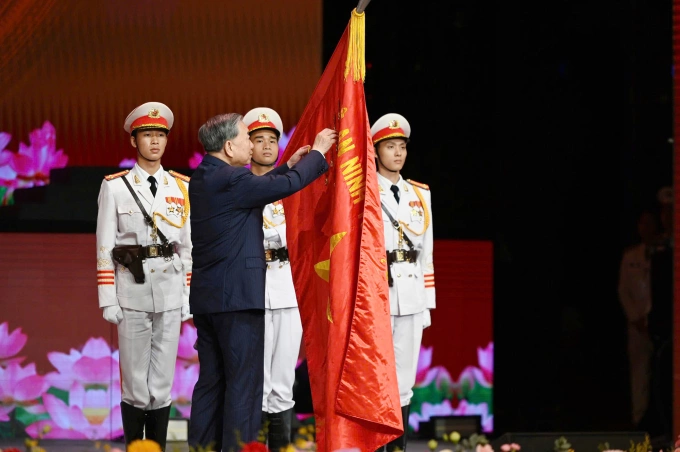 Tổng Bí thư Tô Lâm gắn Huân chương Sao Vàng lên cờ truyền thống của lực lượng Công an nhân dân. Ảnh: Hoàng Phong