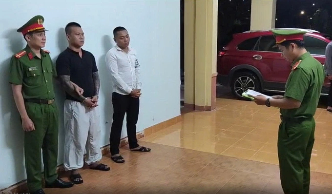 Đồng Phước Hiệu (áo đen) và Nguyễn Tường nghe đọc lệnh bắt giam. Ảnh: Công an cung cấp