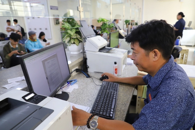 Anh Hoách Văn Duyên, cán bộ Trung tâm phục vụ hành chính công phường Gò Vấp, phụ trách lĩnh vực công thương, điền thông tin của người dân lên hệ thống từ bản chụp hồ sơ, ngày 6/8. Ảnh: Lê Tuyết