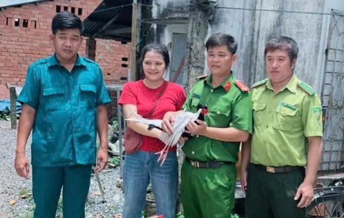 Chị Lợi giao nộp gà lôi cho lực lượng chức năng. Ảnh: Minh Bằng