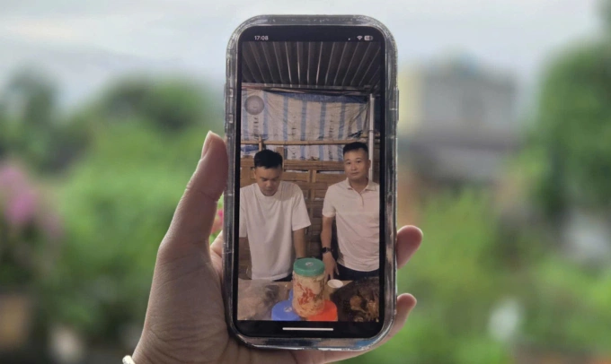 Anh Đức (bên phải) trong một buổi livestream bán măng muối cho dân bản. Ảnh: Lam Sơn