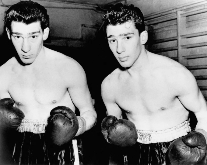 Ronnie (trái) và Reggie Kray bắt đầu sự nghiệp trên võ đài quyền Anh, tập luyện tại Kleins Gym ở London. Ảnh: Alamy