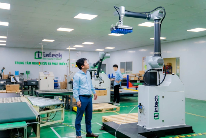 Ông Hoàng Hữu Thắng thử nghiệm vận hành mẫu robot do Intech Group phát triển. Ảnh: Intech
