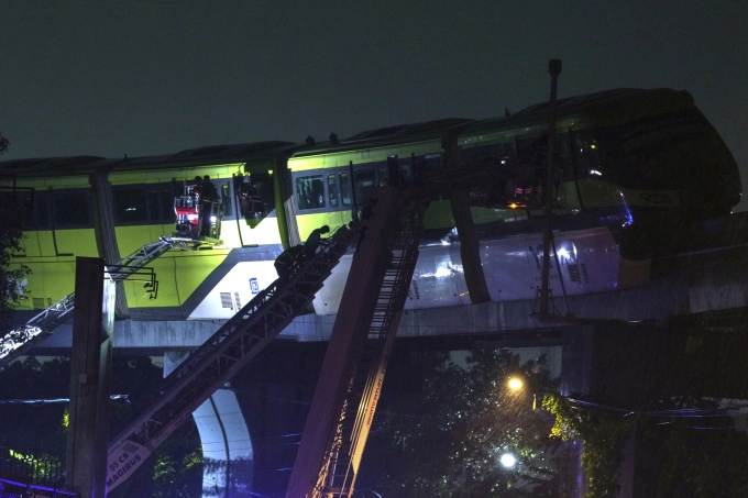 Đội cứu hỏa giải cứu hành khách mắc kẹt trên tàu điện ở Mumbai, Ấn Độ, tối 19/8. Ảnh: AP