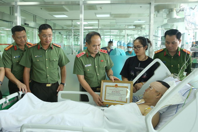 Trung tướng Nguyễn Thanh Tùng trao Bằng khen của Chủ tịch Hà Nội cho đại úy Công. Ảnh: Công an Hà Nội