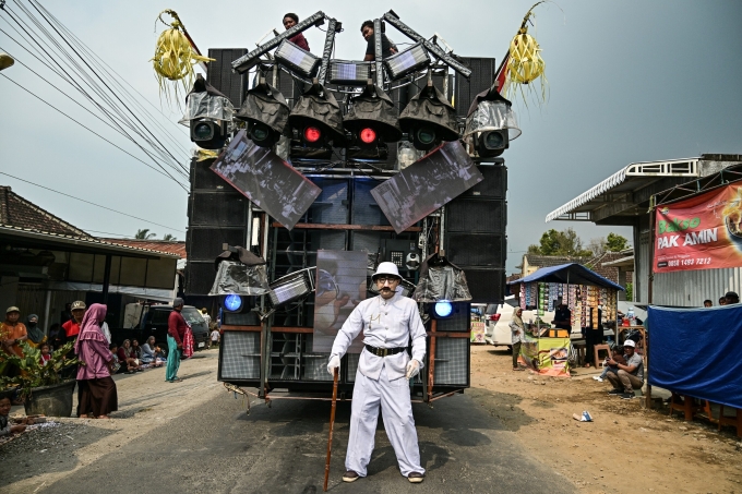 Một nghệ sĩ chụp ảnh trước xe tải gắn đầy loa ở Malang, Đông Java, Indonesia ngày 9/8. Ảnh: AFP