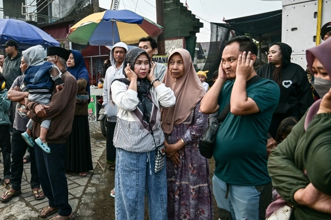 Người dân bịt tai khi một tháp loa đi qua trong một sự kiện ở thành phố Malang, Đông Java, Indonesia ngày 9/8. Ảnh: AFP