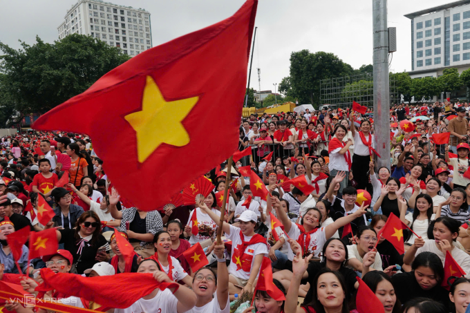Người dân cầm cờ Tổ quốc đón đoàn diễu binh, diễu hành gần quảng trường Ba Đình. Ảnh: Ngọc Thành