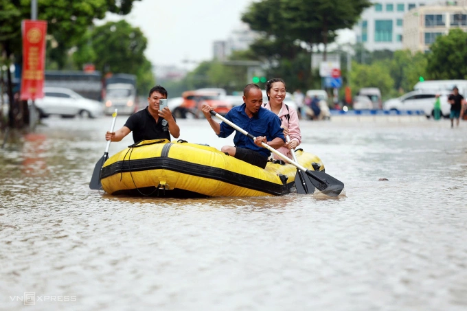 Đường Dương Đình Nghệ, phường Cầu Giấy, ngập sâu một mét, người dân dùng xuồng di chuyển. Ảnh: Đức Đồng