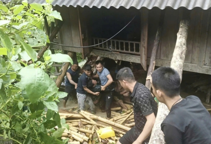 Lực lượng cứu hộ và người dân đưa hai nạn nhân ra khỏi vị trí bị vùi lấp. Ảnh: BĐBP