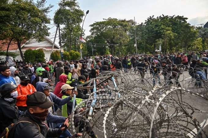 Người biểu tình kéo dây thép gai trong cuộc biểu tình trước dinh thống đốc ở Surabaya ngày 29/8. Ảnh: AFP