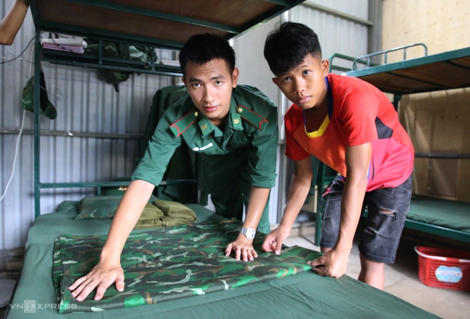 Hồ Lanh được bộ đội biên phòng hướng dẫn xếp chăn màn ngăn nắp. Ảnh: Đắc Thành