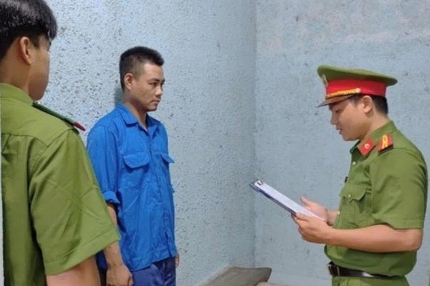 Nguyễn Ngọc Quang nghe cảnh sát đọc lệnh bắt tạm giam. Ảnh: Công an cung cấp