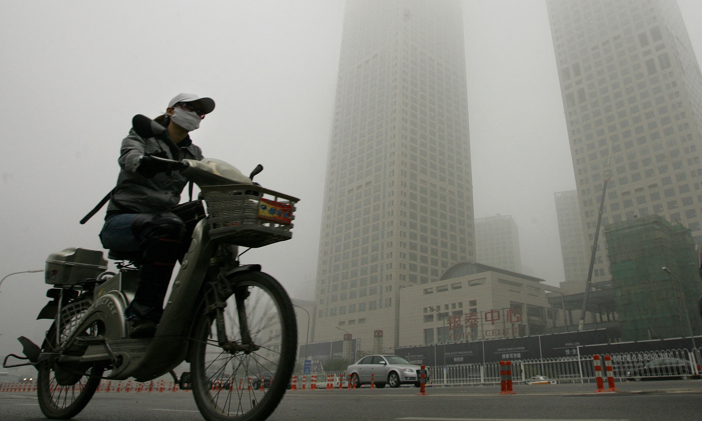 Người dân đeo khẩu trang đi xe đạp tại Bắc Kinh tháng 10/2007. Ảnh: AFP AFP-20071026-Hkg794868-v1-High-3084-2288
