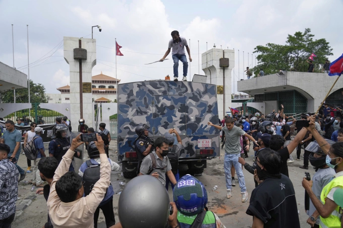 Người biểu tình bao vây xe bọc thép cảnh sát bên ngoài tòa nhà quốc hội ở Kathmandu, Nepal, ngày 8/9. Ảnh: AP