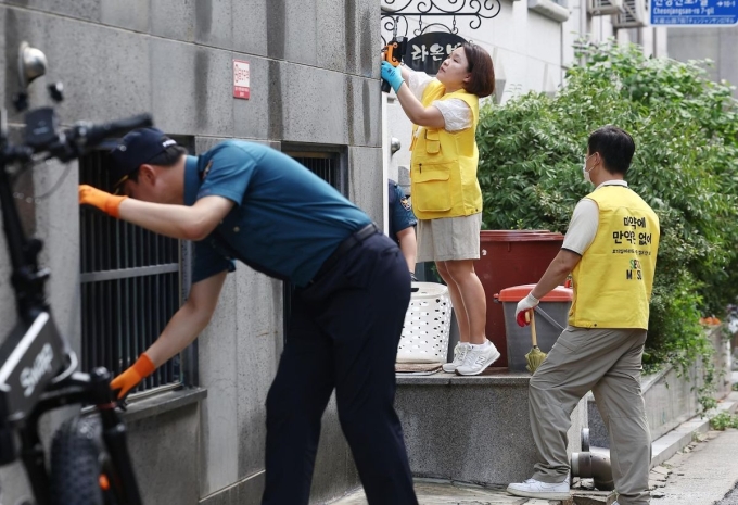 Nhóm thanh tra tìm kiếm ma túy được giấu kín để người mua tự đến lấy, gần khu vực trường đại học ở Seoul, ngày 26/8. Ảnh: Hankookilbo