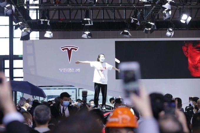 Zhang Yazhou trèo lên xe trưng bày ở triển lãm ôtô tại Thượng Hải, tháng 4/2021. Ảnh: Caixin