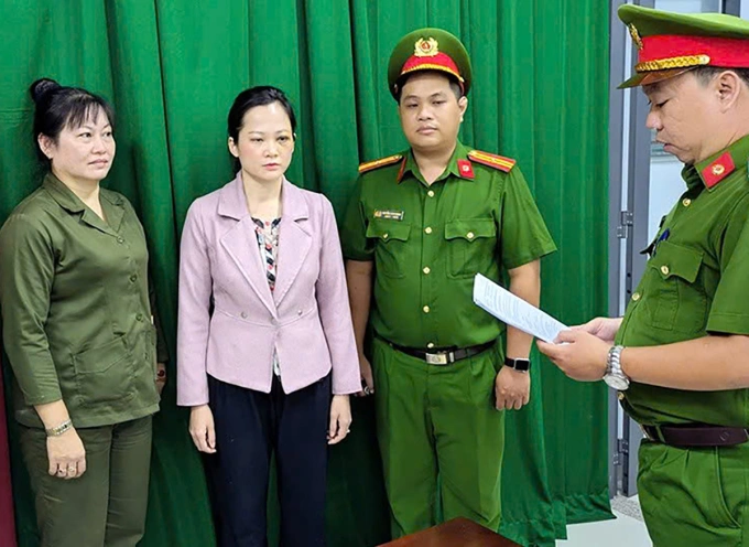 Bà Tuyết Chinh (áo hồng) tại cơ quan điều tra. Ảnh: Công an cung cấp