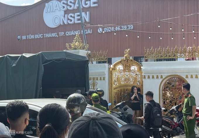 Một cô gái bị cảnh sát đưa ra khỏi quán và đưa lên xe chở về đồn. Ảnh: Phạm Linh