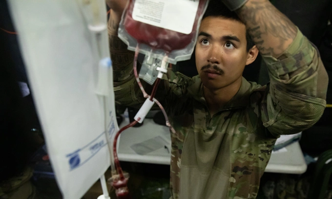 Lính quân y Mỹ bóp túi để đẩy nhanh quá trình truyền máu trong diễn tập ngày 12/9. Ảnh: US Army