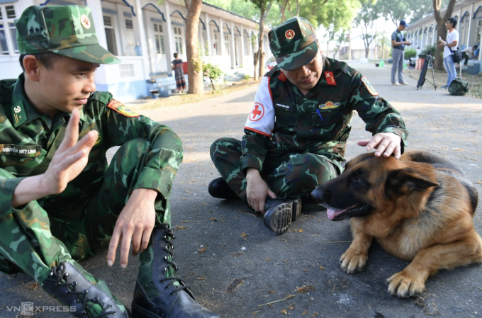 Phút nghỉ ngơi của bộ đội Việt Nam và quân khuyển sau nhiều giờ tìm kiếm nạn nhân động đất Myanmar, tháng 3/2025. Ảnh: Thành Đạt