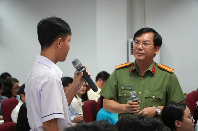Thượng tá Trần Văn Đông, Phó Phòng An ninh Chính trị Nội bộ (PA03), Công an TP HCM, trao đổi với học sinh tại hội thảo, sáng 18/9. Ảnh: Thanh Phúc