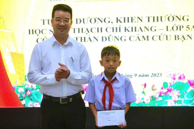 Ông Nguyễn Đình Tâm, Chủ tịch UBND phường Thành Nhất khen thưởng cho em Thạch Chí Khang. Ảnh: Ngọc Oanh