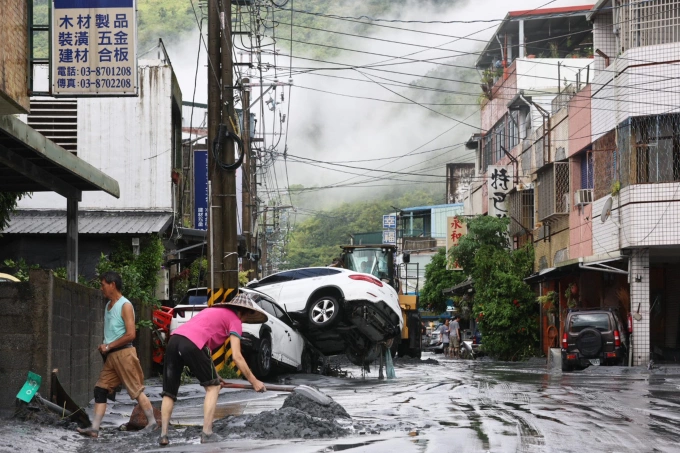 Người dân dọn dẹp đống đổ nát sau vụ vỡ hồ chứa ở huyện Hoa Liên, đảo Đài Loan, ngày 24/9. Ảnh: AFP
