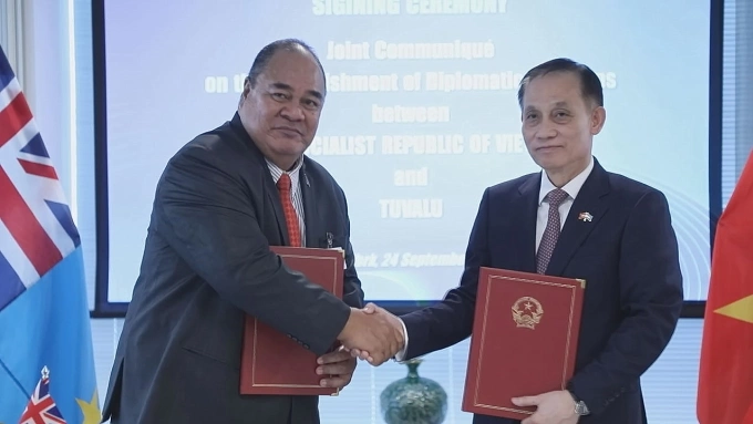 Quyền Bộ trưởng Ngoại giao Lê Hoài Trung (phải) và Bộ trưởng Ngoại giao, Lao động và Thương mại Tuvalu Paulson Panapa trao thông cáo chung thiết lập quan hệ ngoại giao giữa hai nước ngày 24/9. Ảnh: BNG