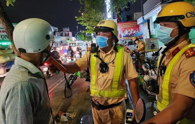 Cảnh sát kiểm tra nồng độ cồn tài xế ở giao lộ Thoại Ngọc Hầu - Lũy Bán Bích, quận Tân Phú cũ. Ảnh: Đình Văn
