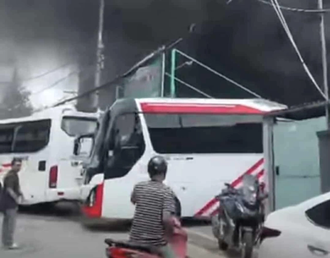 Nhiều người đã nhanh chóng di dời 3 xe giường nằm, một ôtô 7 chỗ từ trong bãi ra ngoài, tránh cháy lan. Ảnh: Minh Bằng