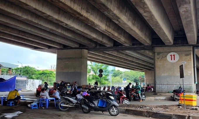 Đoạn cuối dạ cầu Phú Mỹ (quận 7 cũ) bị chiếm dụng buôn bán nước giải khát, để bàn ghế, xe máy trái quy định. Ảnh: Đình Văn