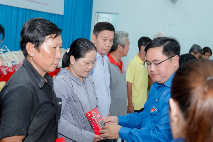 Phó bí thư tỉnh đoàn tỉnh Vĩnh Long (áo xanh) trao tặng điện thoại cho người dân. Ảnh: Quỹ Hỗ trợ Cộng đồng Đinh Thiện Lý