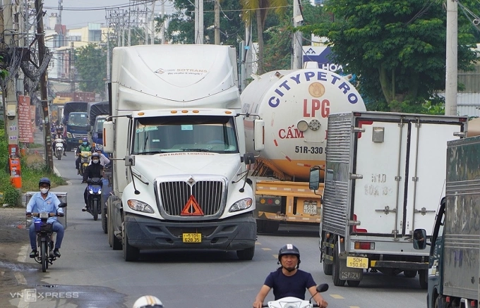Đường Nguyễn Duy Trinh, đoạn gần cảng Phú Hữu nhỏ hẹp nhưng lượng ôtô tải, xe container rất đông. Ảnh: Gia Minh