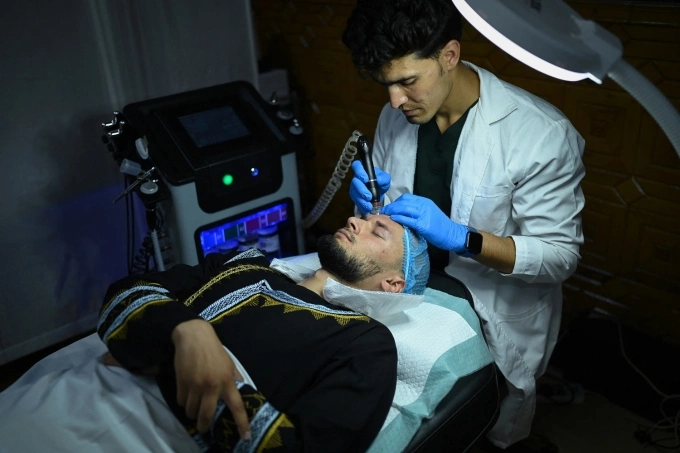 Một khách hàng nam đang thực hiện liệu pháp chăm sóc da mặt chuyên sâu trong phòng khám thẩm mỹ ở Kabul ngày 13/8. Ảnh: AFP